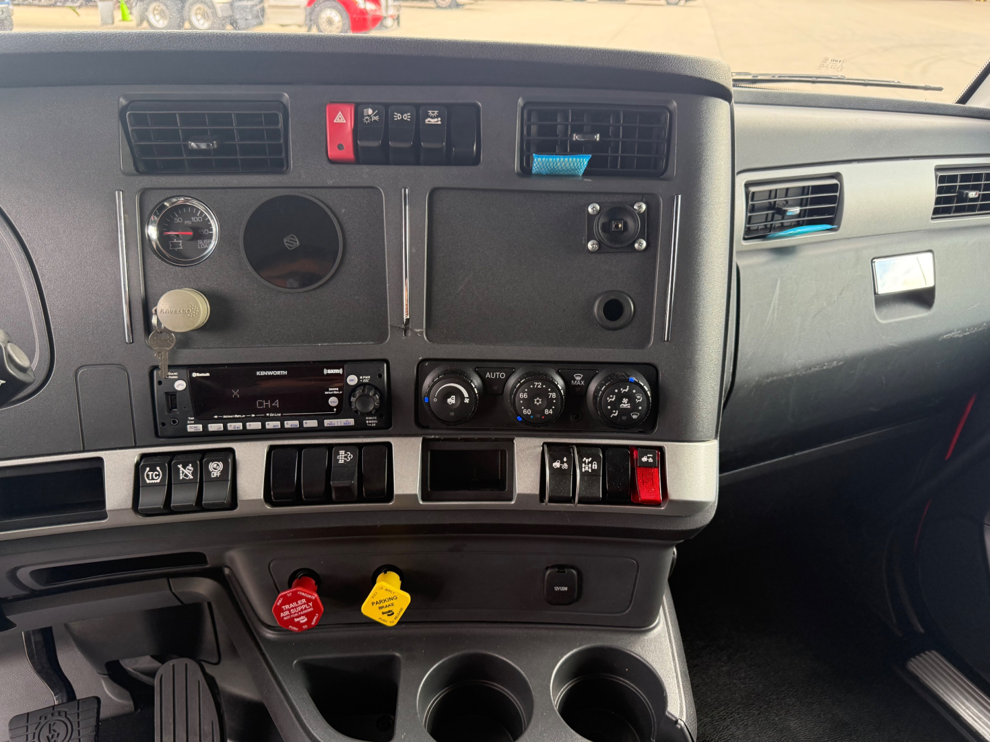 Kenworth T680 instrument cluster and center console with various switches and gauges visible.