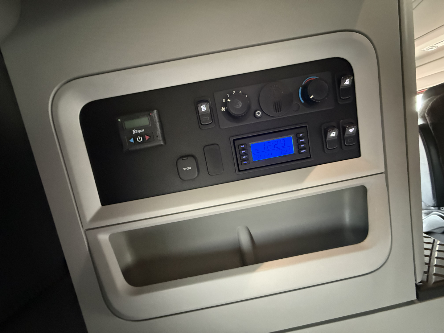 Kenworth T680 sleeper cab interior console with dashboard controls and blue-lit display.