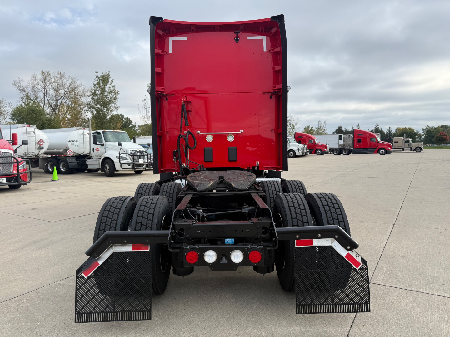 Kenworth T680 rear view showing dual rear axles, mud flaps, and fifth wheel assembly.