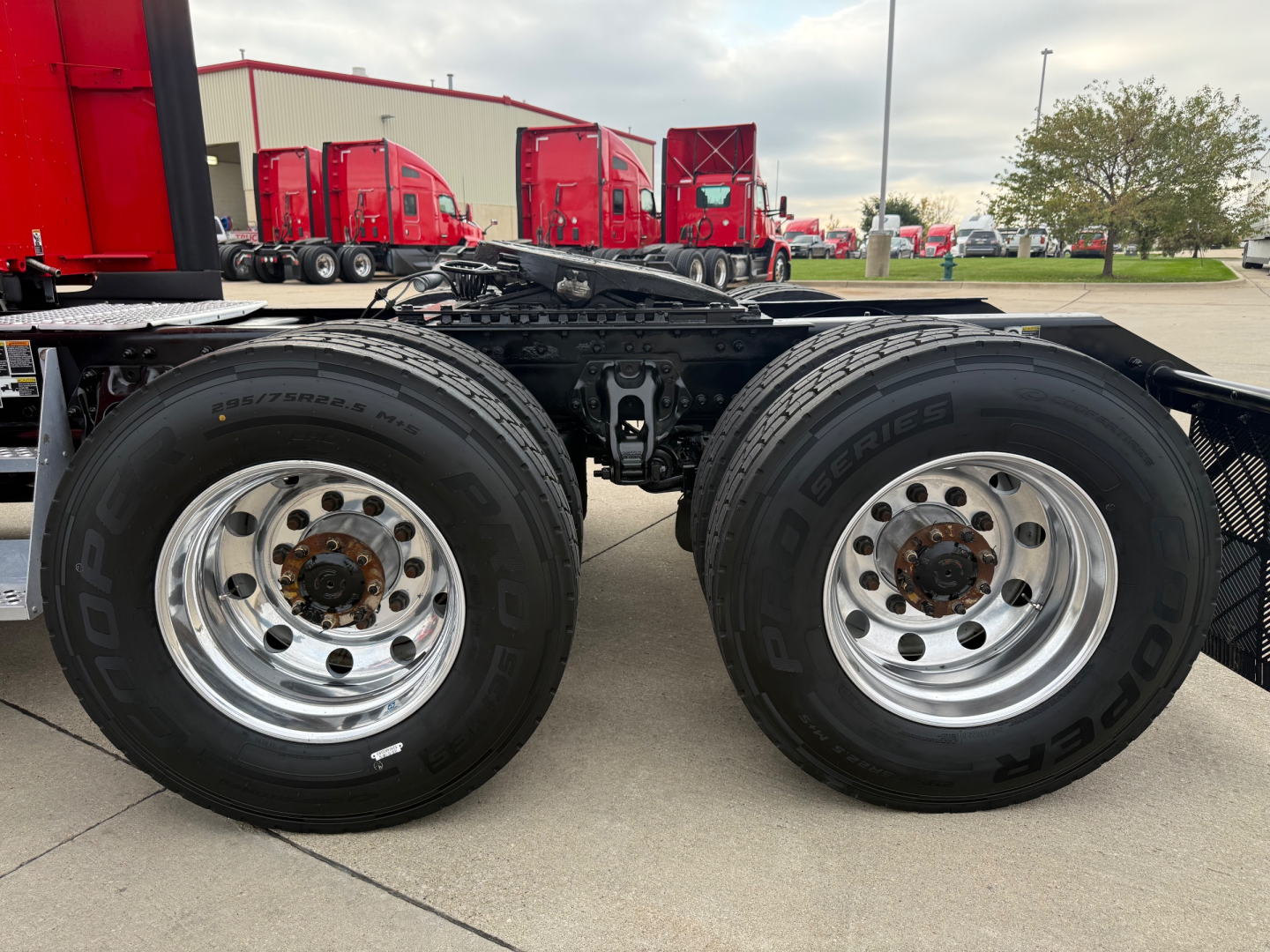 Kenworth T680 truck tandem wheels showing dual rear axles with chrome rims and black tires, part of a sleeper tractor chassis.