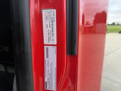 Vehicle door jamb showing multiple certification labels and barcodes on a red 2022 Kenworth T680 truck.