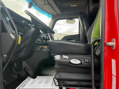  Kenworth truck interior showing driver seat with controls and dashboard; visible steering wheel, pedals, and door frame.