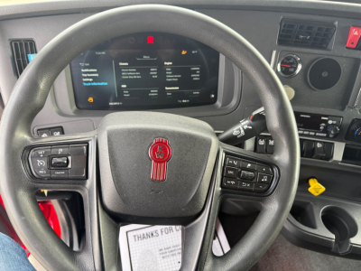 Kenworth T680 steering wheel and dashboard showing instrument cluster and control buttons.