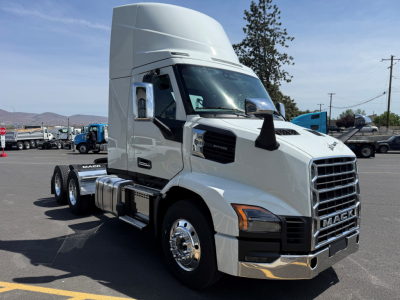 Conventional daycab truck front-left view showing Mack AN64T cab with chrome grille and dual rear axles.
