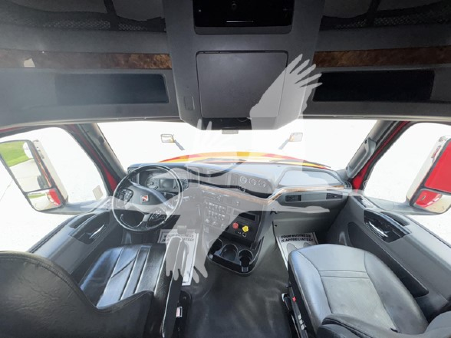 Truck cab interior view of a 2019 International LT sleeper showing steering wheel, dashboard, center console, and seats.