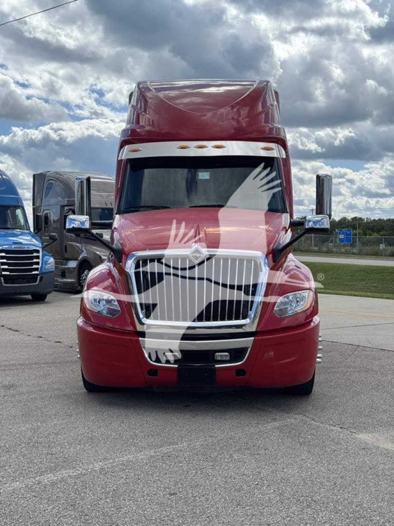 Front view of a red 2019 International LT truck in a parking lot, grille, headlights, and white bowtie emblem visible.