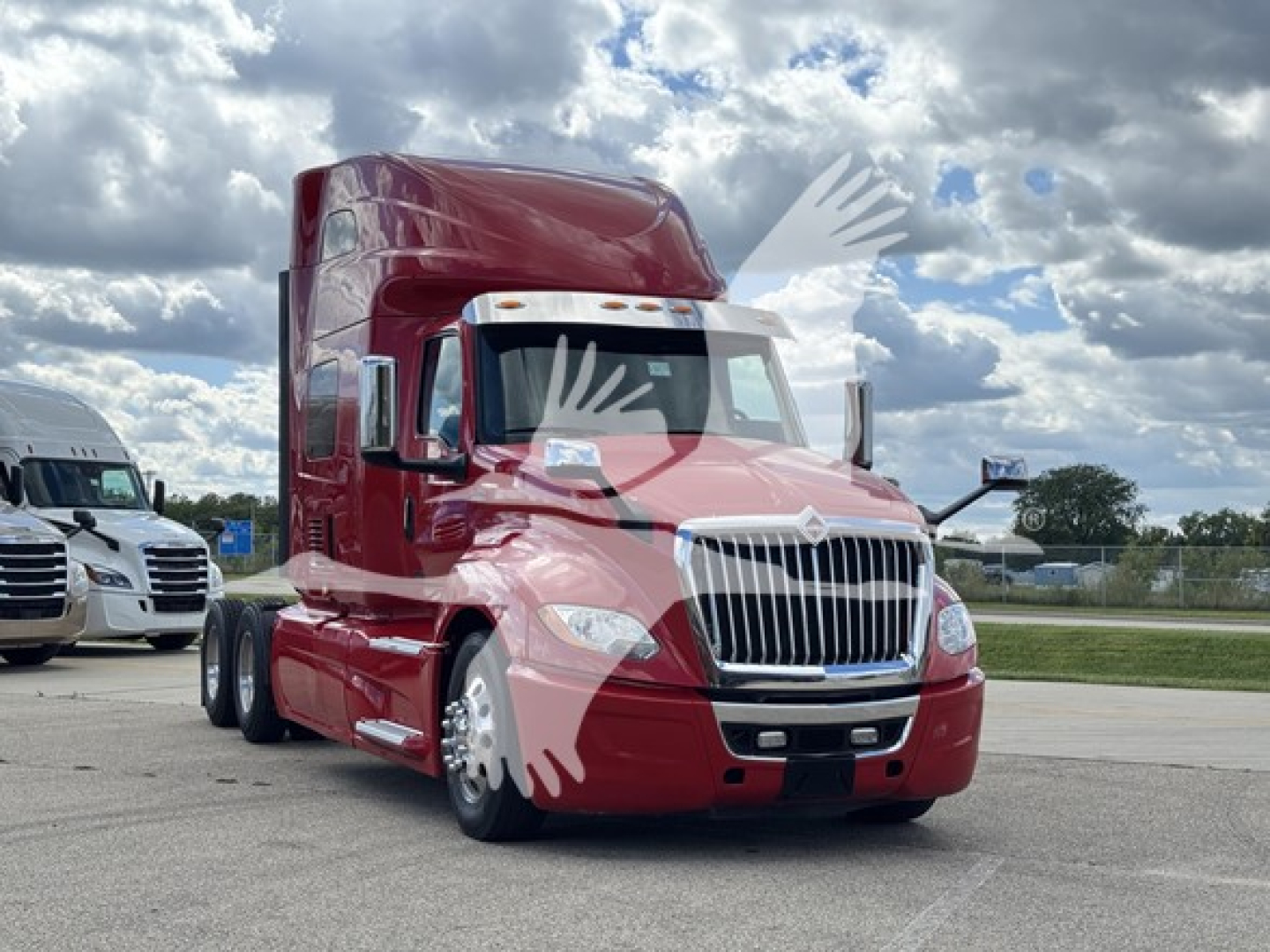 Semi-truck in red exterior with high sleeper cabin, front grille, and chrome bumper. No visible text on the truck itself.