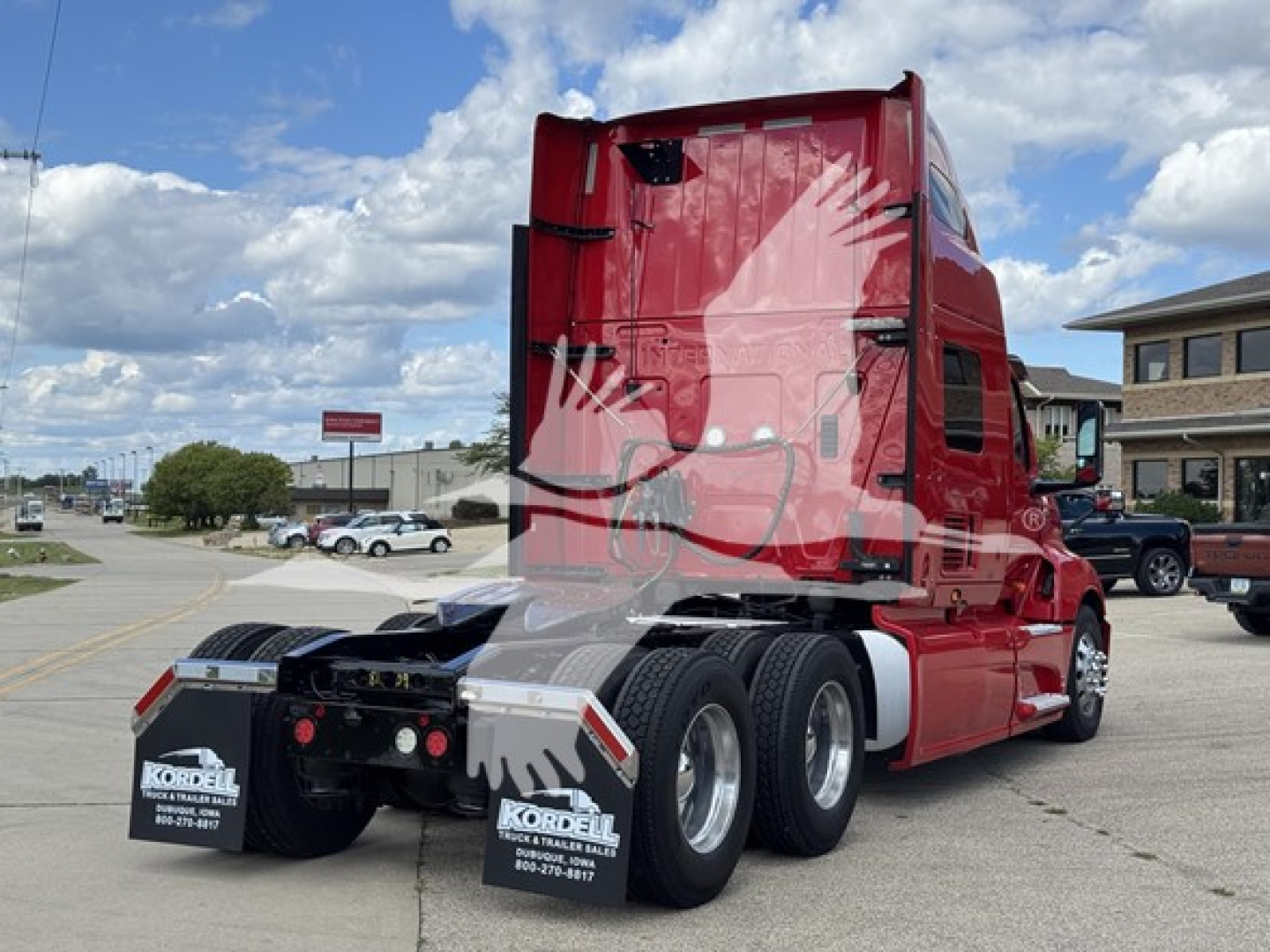 Truck cab with red exterior shown from rear three-quarter view; International LT logo not visible; rear wheels and fifth wheel visible; clear sky