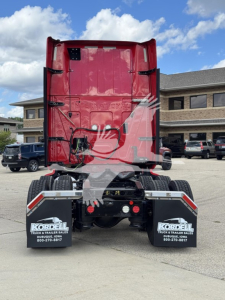 Rear view of red 2019 International LT sleeper tractor showing fifth-wheel area, dual rear mudflaps with Korbel dealership branding, and exhaust outlet.