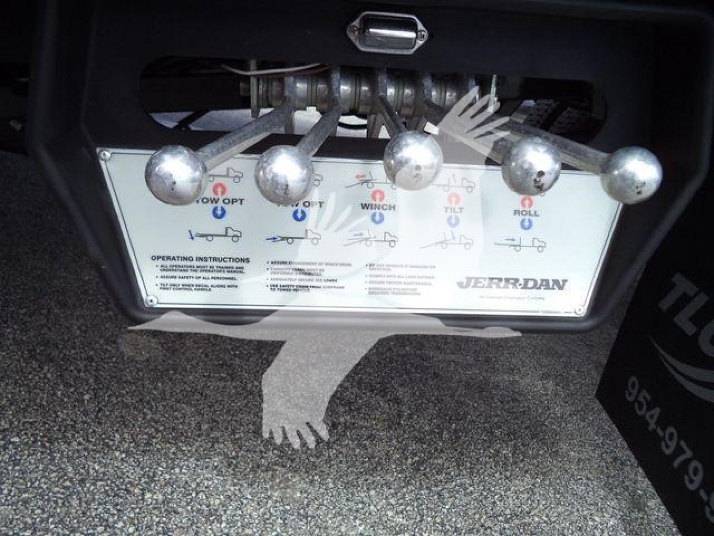 Truck control panel with four levers and diagrams, Jerr-Dan branding, showing operation instructions and labels.