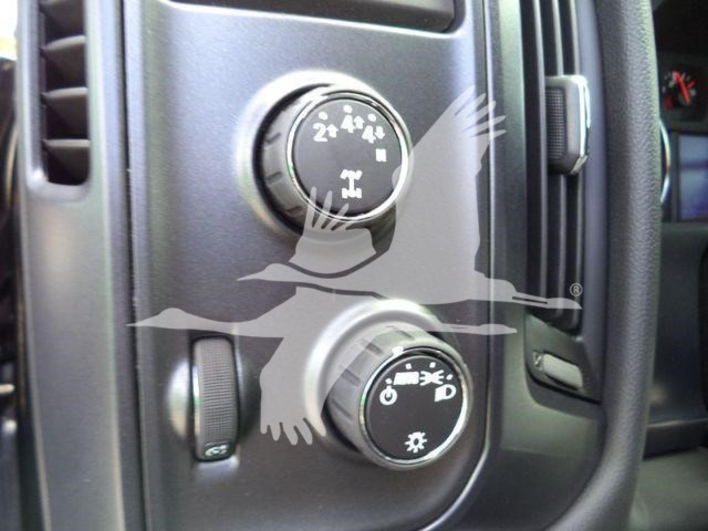 Dashboard controls showing two knobs for climate settings and a small lever; knob symbols indicate air flow modes.