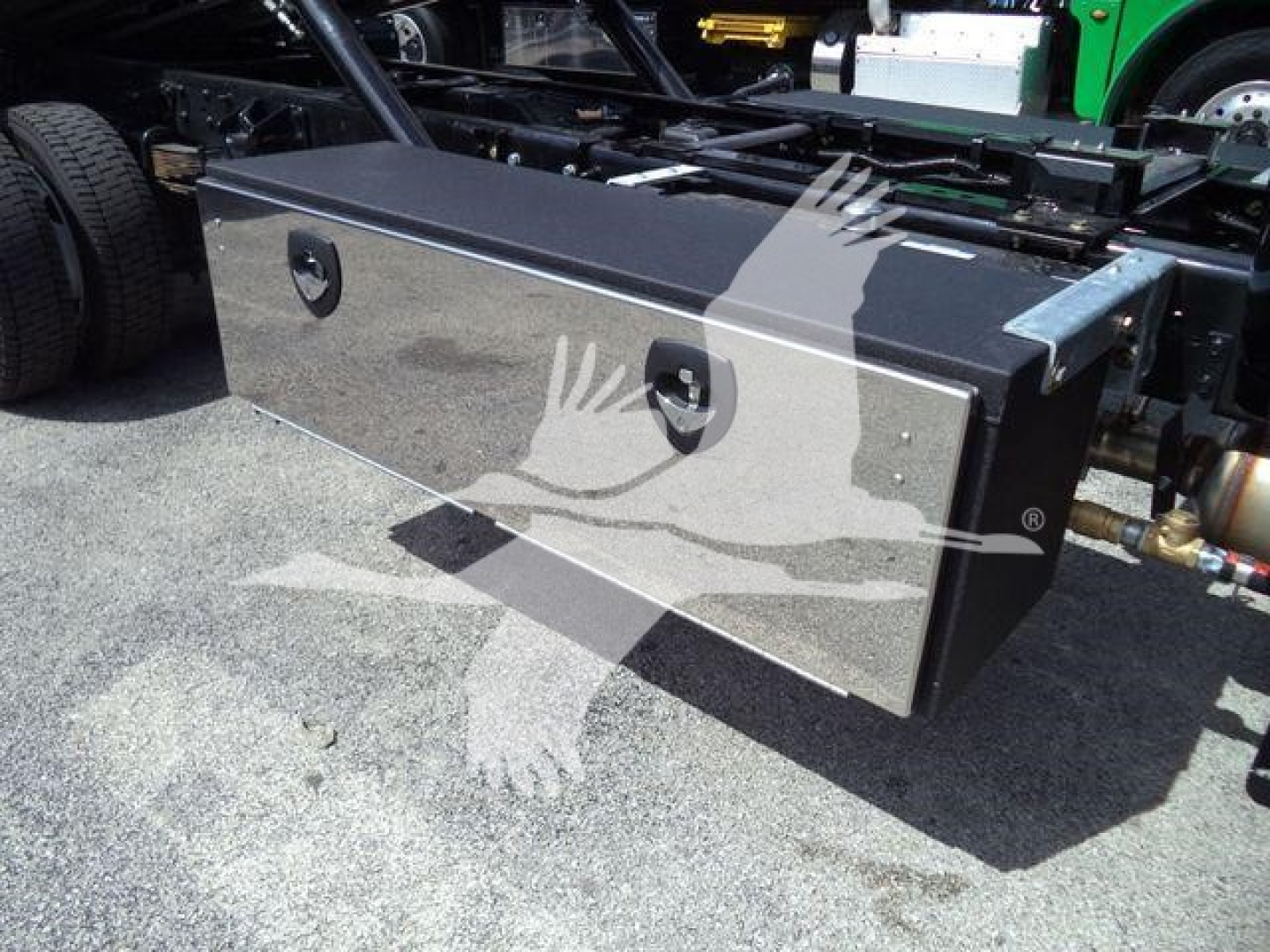 Aluminum toolbox mounted on truck frame with two circular lock handles and metallic finish.