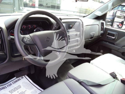 Truck cab interior showing steering wheel and dashboard of a 2023 International CV with gray seats and center console.