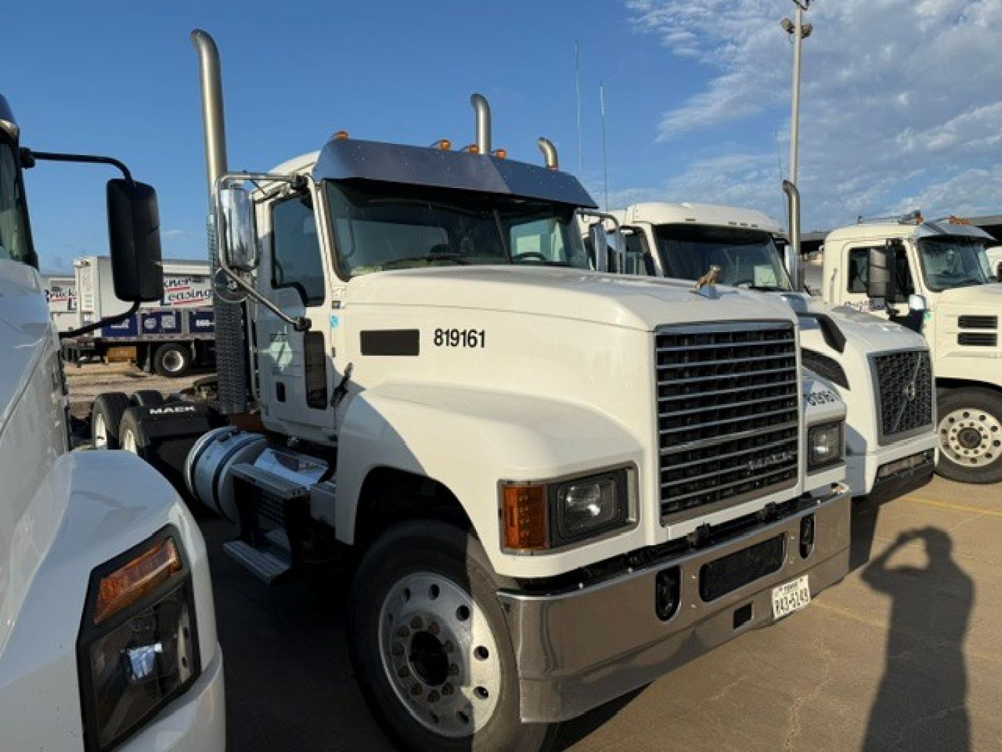 Tractor truck front view of a white 2019 Mack PI64T conventional daycab showing chrome grille, headlights, large bumper, and side mirrors.