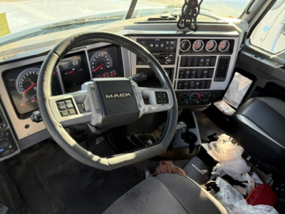 Cab interior of a 2019 Mack PI64T daycab showing steering wheel with Mack emblem and instrument cluster, center console controls, and dashboard gauges.