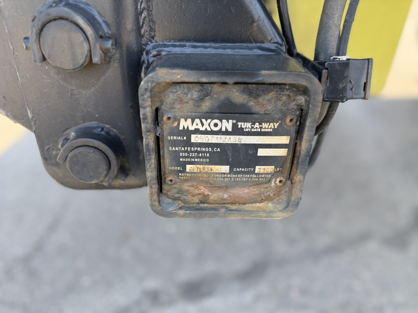 Maxon TUK-A-WAY label on hitch visible with serial/model information, attached to a black hitch assembly.