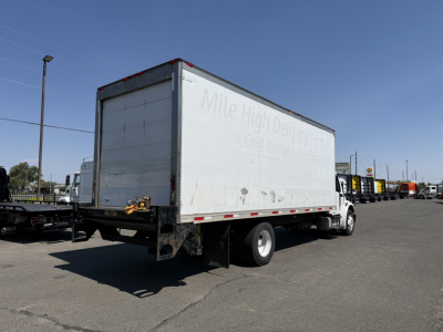 Freightliner M2106 box truck from rear three-quarter view showing refrigerated body and white cab.