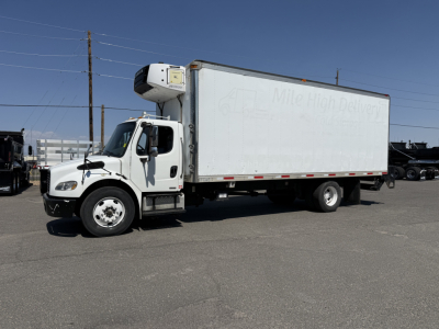 Freightliner M2106 refrigerated truck with white box and side refrigeration unit, side view showing cab and cargo area.