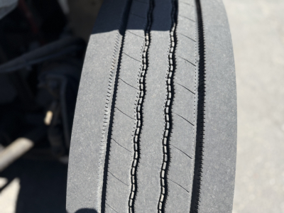 Trailer or truck tire with detailed tread pattern visible; no additional text readable.