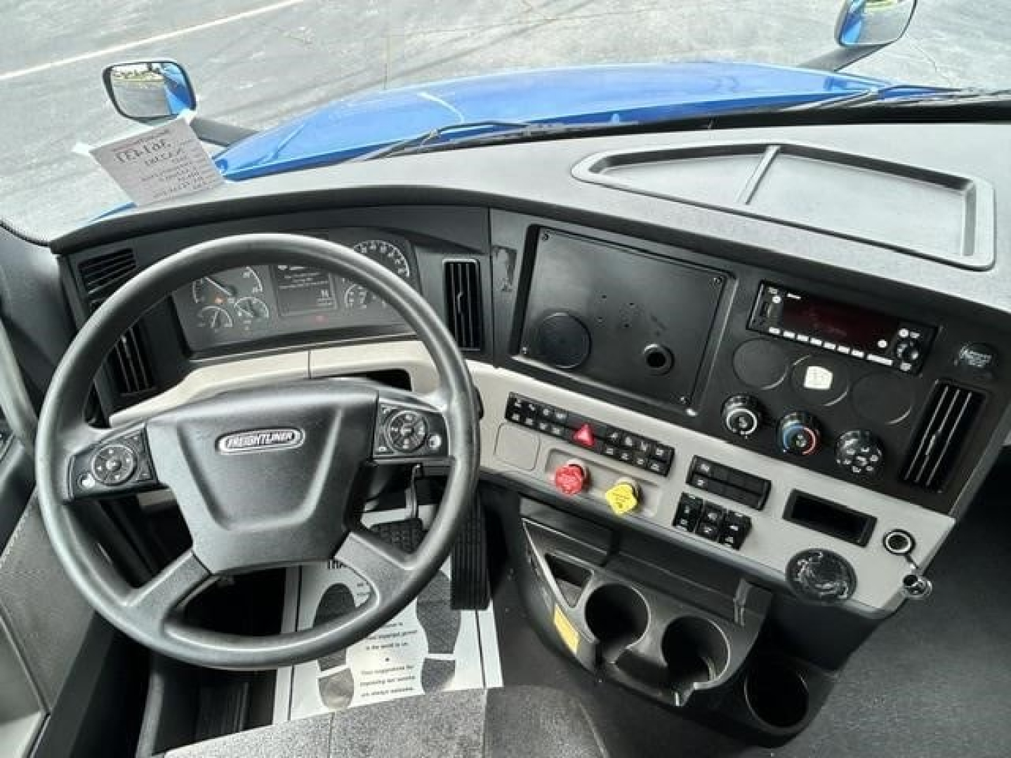 Interior cab view of a Freightliner Cascadia 126 showing steering wheel, dashboard, gauges, and control panel.