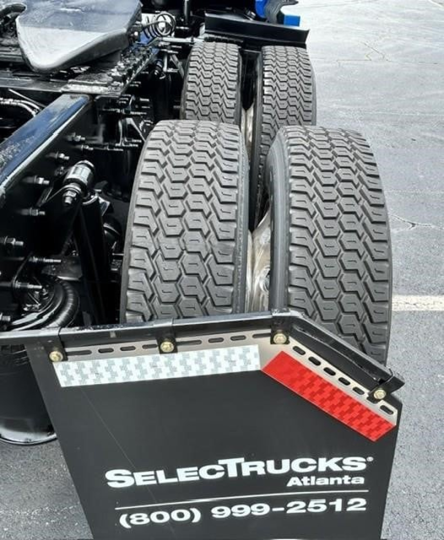 Rear view of a Freightliner Cascadia truck chassis showing dual rear axles and bumper with reflecting tape and 'SelectTrucks Atlanta' branding.