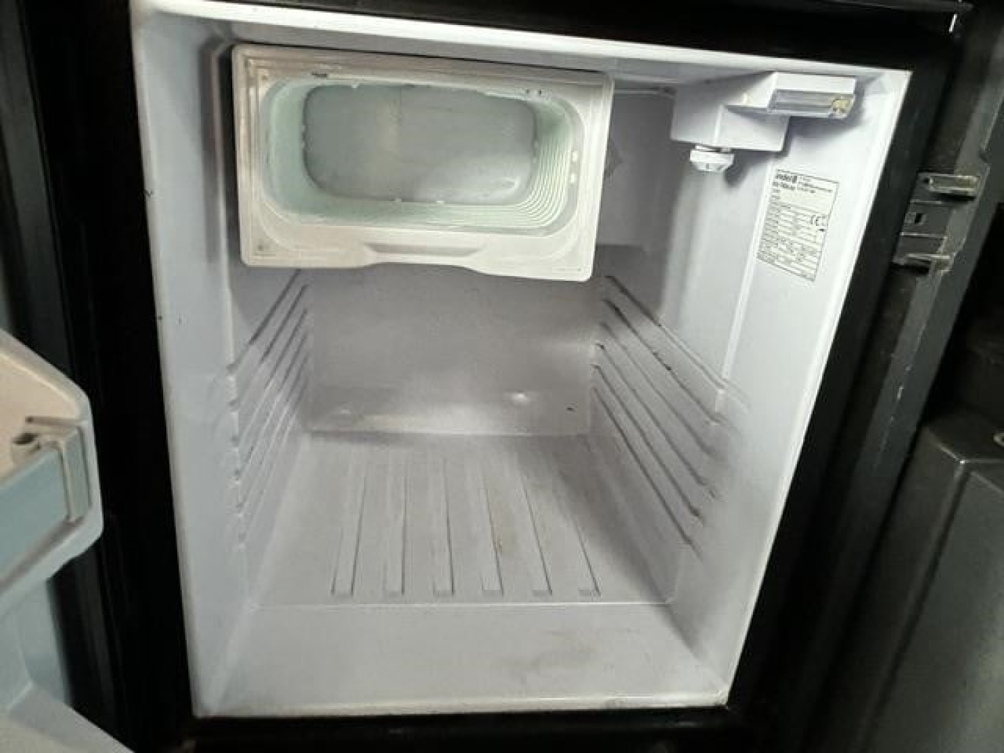 Freightliner Cascadia cab interior showing a small freezer unit mounted at the front wall.