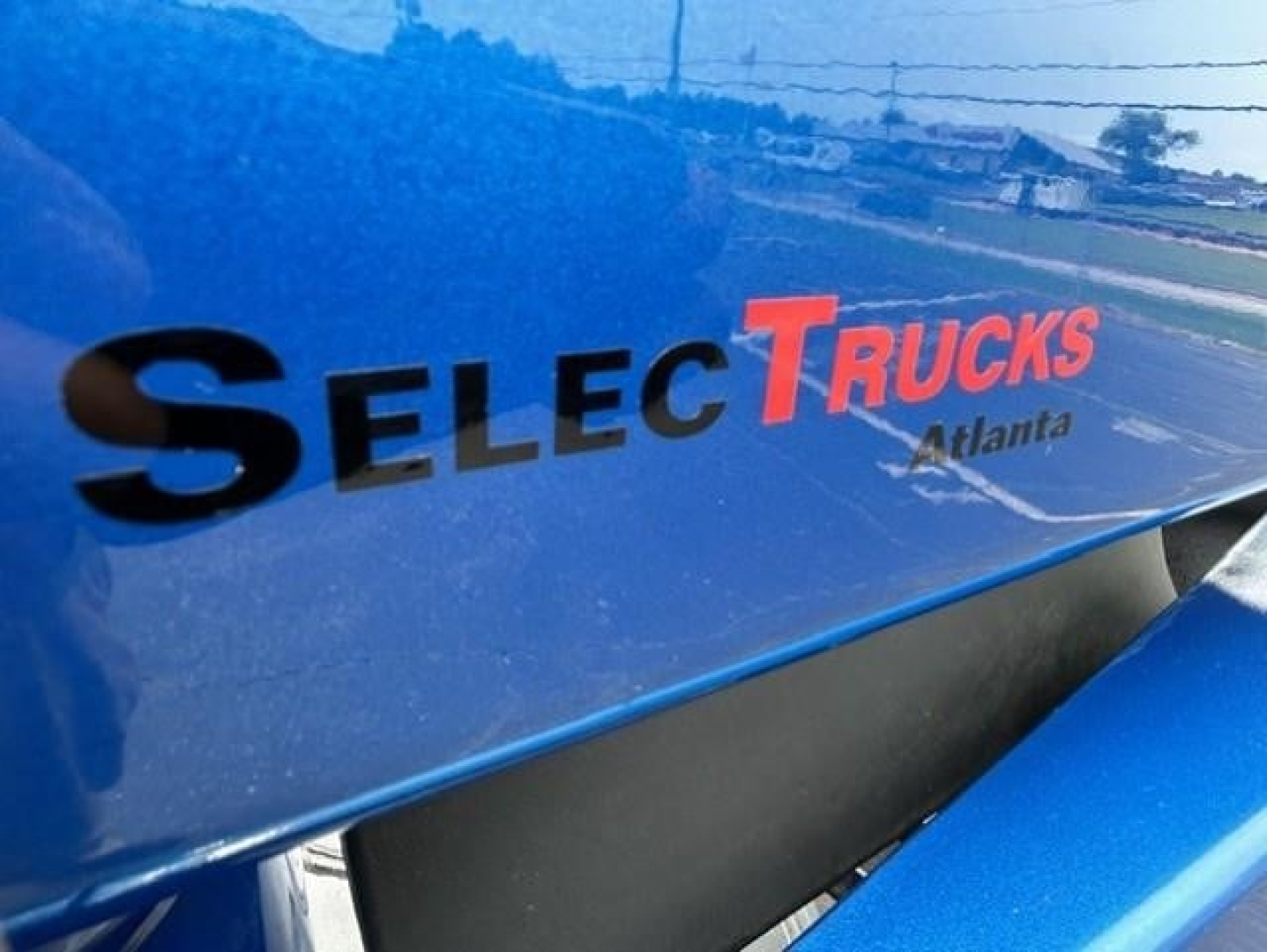 Selective Trucks Atlanta badge on blue truck side panel showing Select Trucks logo