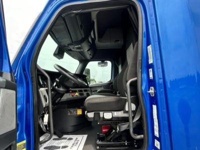  cab interior of a 2022 Freightliner Cascadia 126 truck showing driver seat, steering wheel, dashboard, and doorway