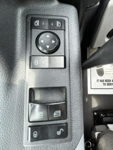 Truck interior switches panel with window controls and mirror adjustment pad. Visible icons include lock/unlock and window controls.