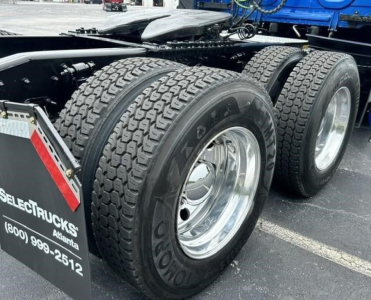 Freightliner Cascadia 126 rear wheels and chassis showing dual rear axle tires and chrome rims.