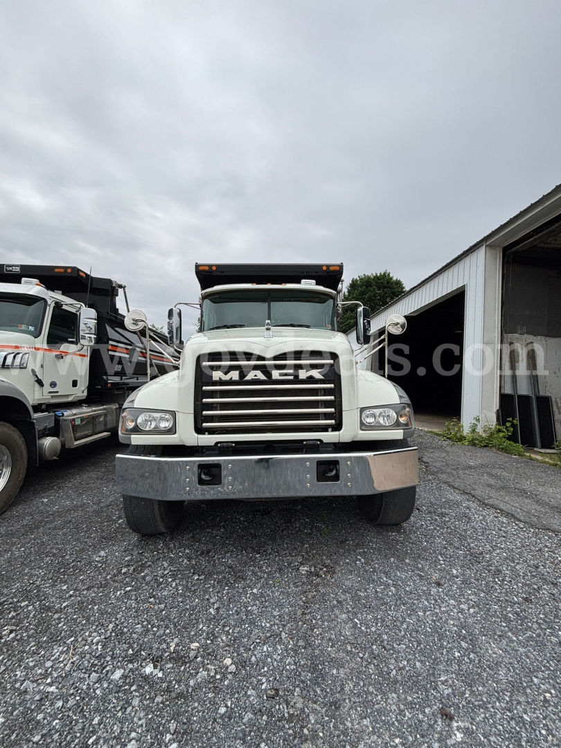 Mack Granite dump truck front view showing grille, headlights, and bumper with a large chrome grill and Mack emblem.