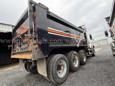 Dump truck bed of a 2020 Mack Granite with dual rear axles showing black body with orange stripes and stock number 29652-808.