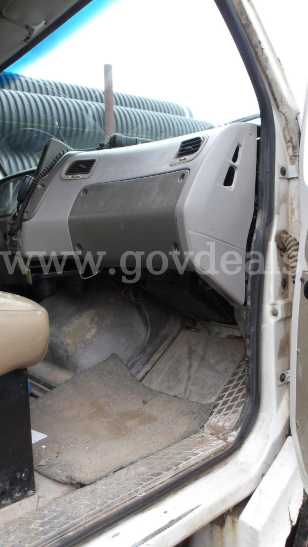 Cab interior of a used Sterling Acterra truck showing the dashboard, steering area, and front floor with dirt and a worn mat.