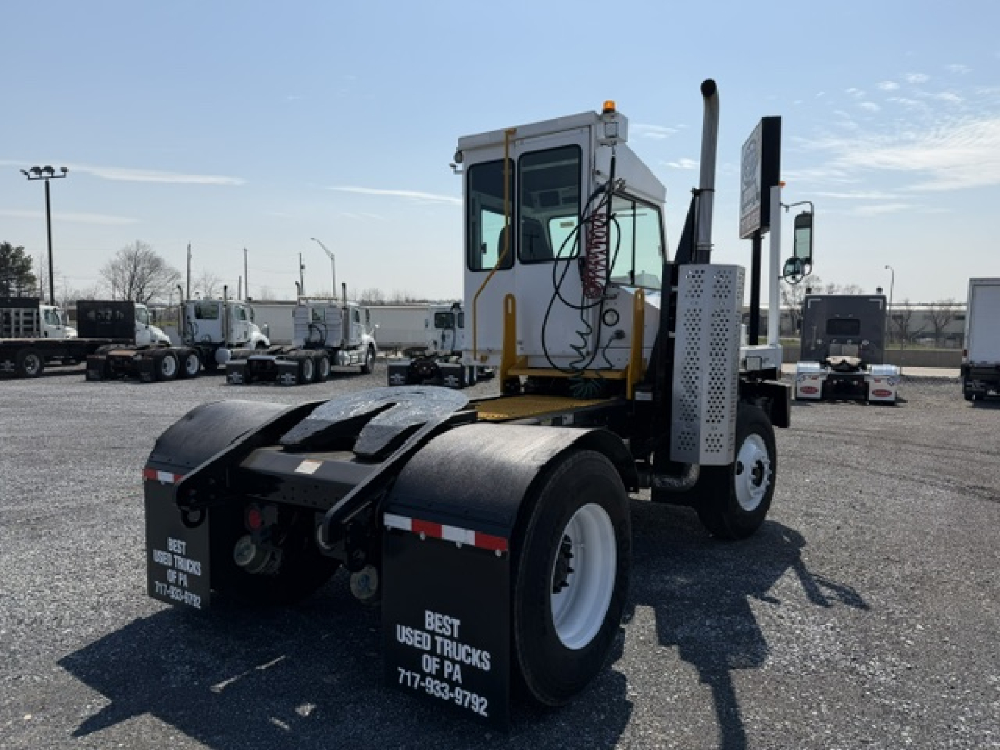 Truck chassis with rear view showing cab and dual rear wheels, with printed text on mudflaps: 'BEST USED TRUCKS OF PA 717-?' along with some numbers.