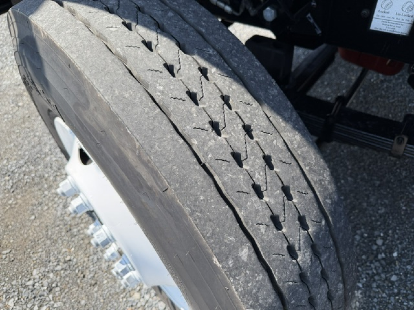 Truck wheel and tire close-up showing tread and lug nuts under a capacity sabre yard truck. 