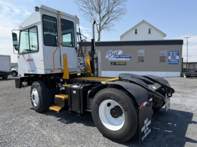 Truck cab and chassis showing capacity sabre yard truck with white cab and yellow steps, rear dual wheels, and fuel tanks visible.