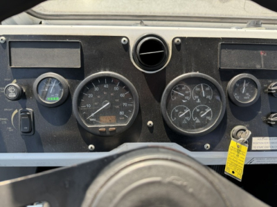 Instrument cluster of 2018 Capacity Sabre truck showing multiple gauges and a yellow tag near ignition area.