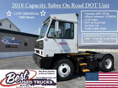 Truck chassis showing 2018 Capacity Sabre On Road DOT Unit with Cab and large front grille in a dealership lot.