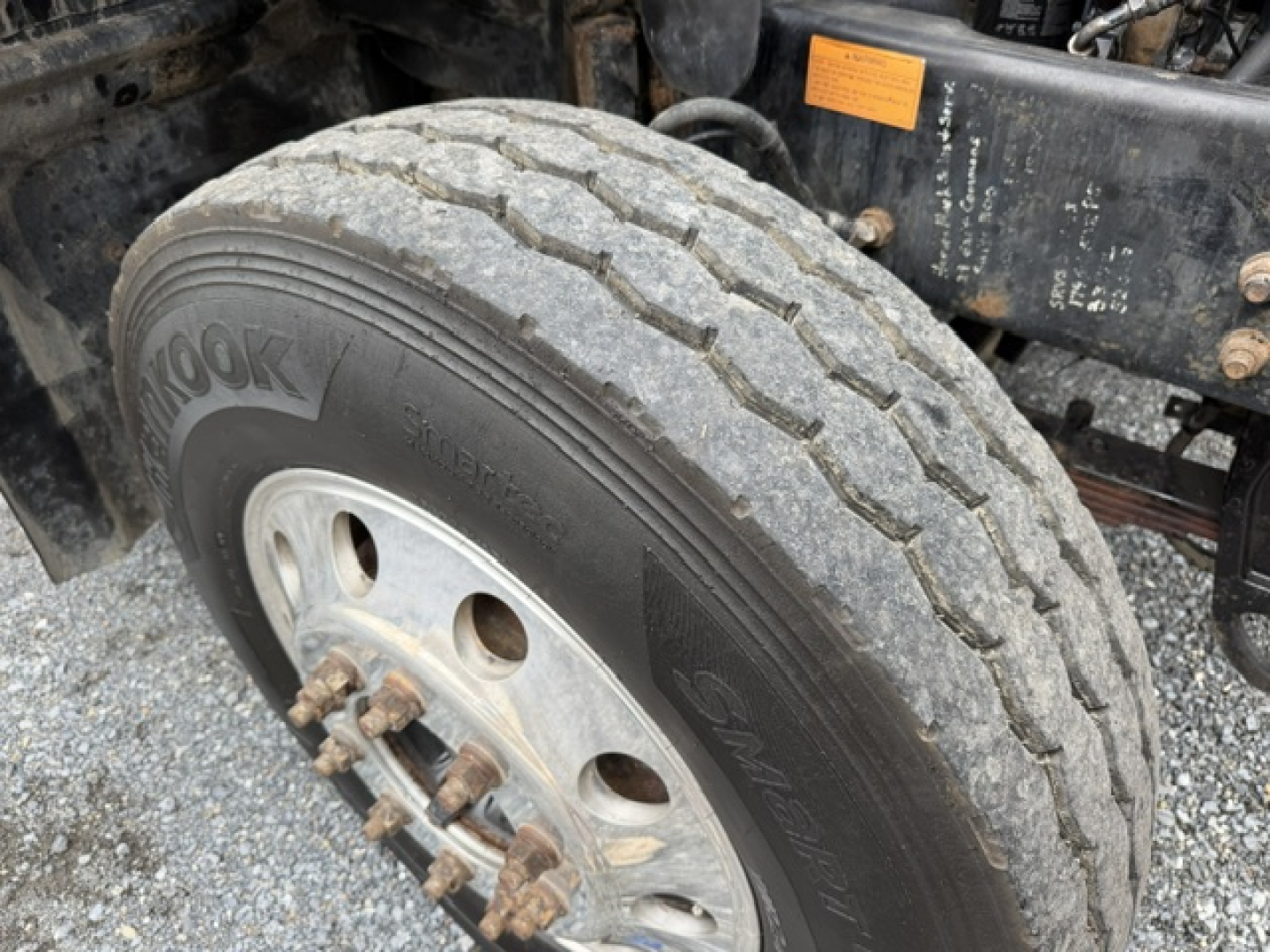 Tire and front wheel area of a 2007 Mack CV713 dump truck showing a Hankook tire and wheel assembly.