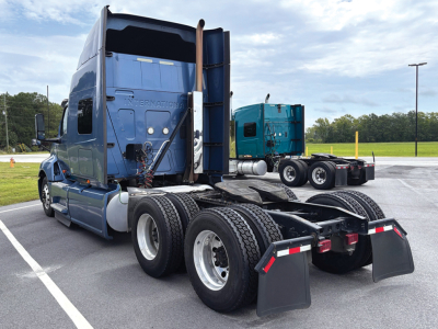Truck rear view showing International LT625 cab with dual rear axles and fifth wheel, two large exhaust stacks, and mud flaps.