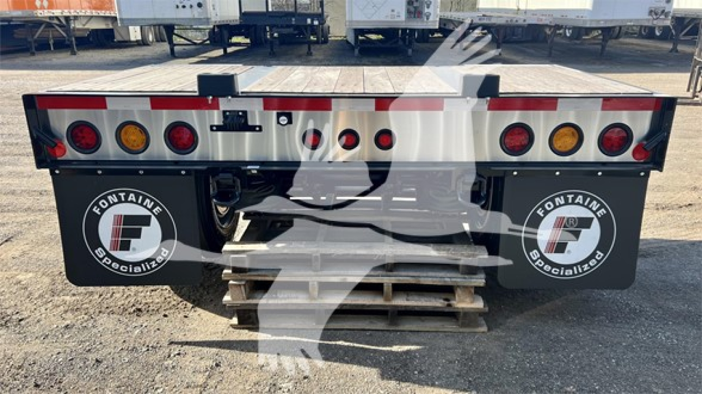Rear view of Fontaine Renegade flip-axle trailer showing taillights and branding stickers on mud flaps.