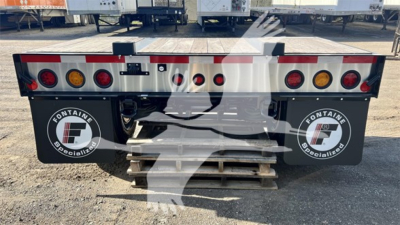 Rear view of Fontaine Renegade flip-axle trailer showing taillights and branding stickers on mud flaps.