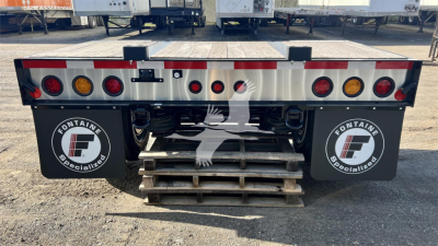 Fontaine Renegade lowboy trailer rear view showing taillights and rear bumper with stained steps and Fontaine logo mud flaps
