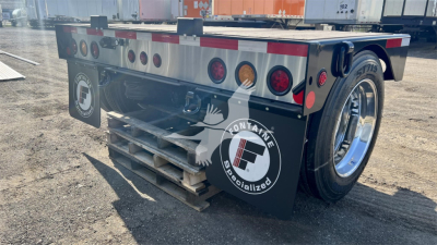 Fontaine Renegade trailer rear with dual rear wheels and reflective safety markings; visible tail lights, mud flaps logos, and a wooden pallet on ground.