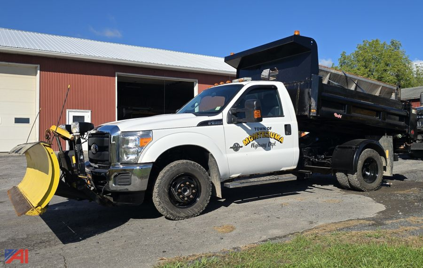 Dump truck with plow and wing attachment front-left view showing service body and rear dump bed, white cab with logo and equipment decals.