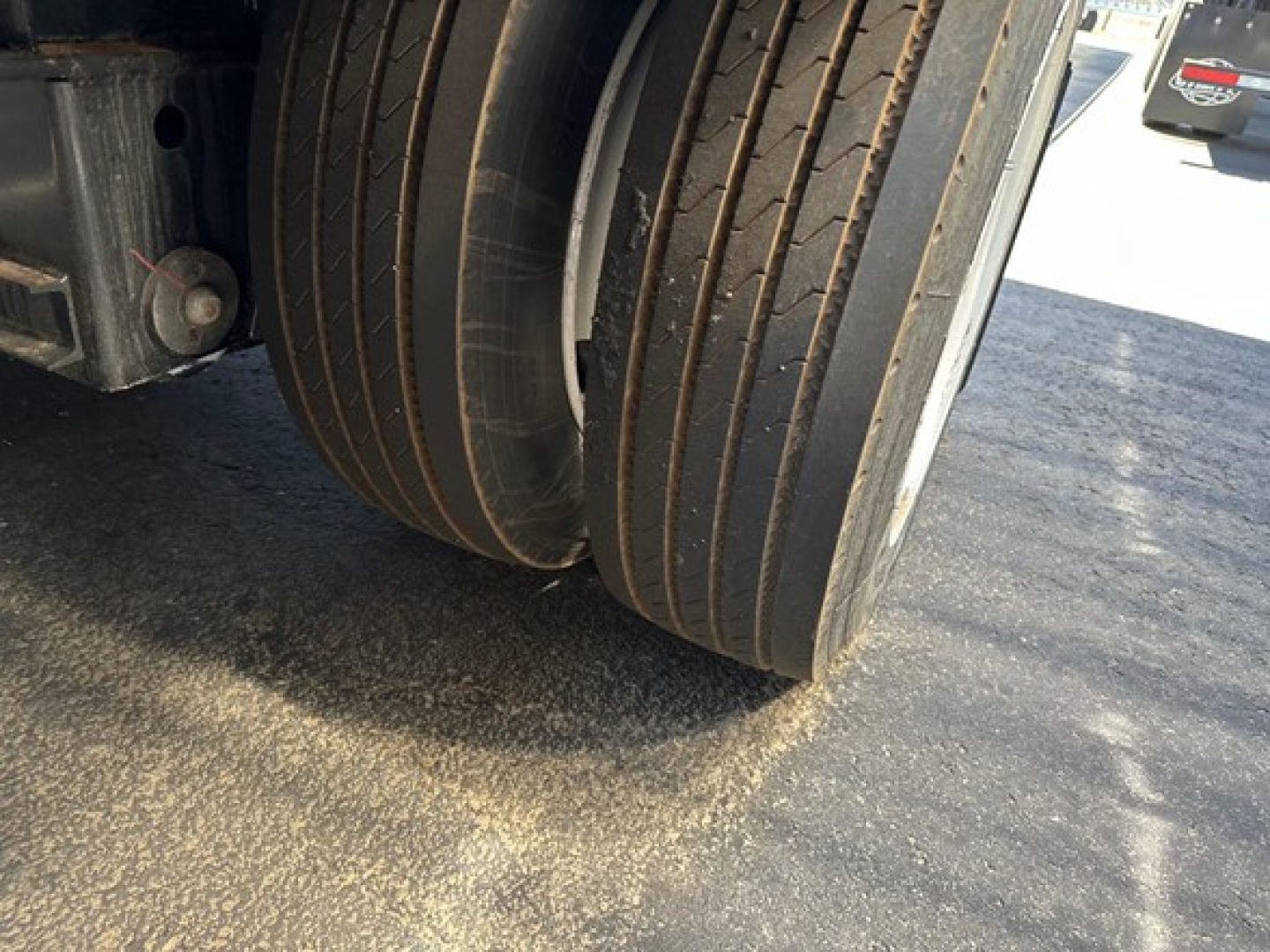 Commercial trailer wheel tires close-up showing dual tires and deck edge.
