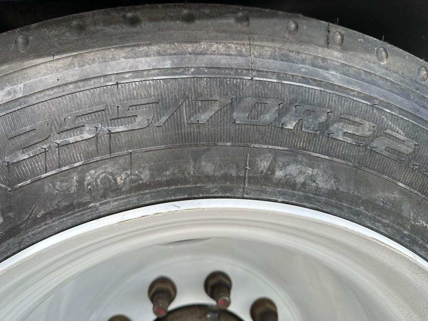 Tire sidewall showing branding and tread with wheel hub visible.