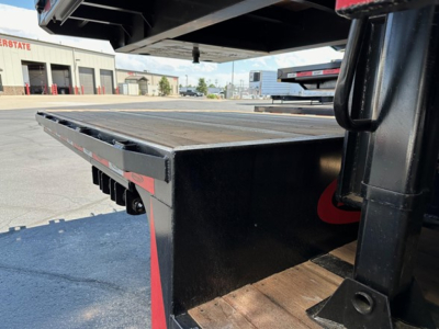 Flatbed trailer deck showing wood platform and steel frame with side rails, part of a 2025 Dura Haul drop deck trailer.