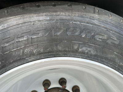 Tire sidewall showing branding and tread with wheel hub visible.
