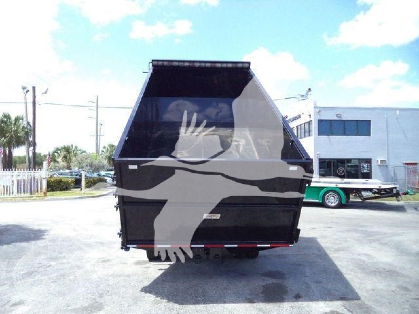 Isuzu truck dump body rear view showing large black dump bed with tailgate; no visible text on body.